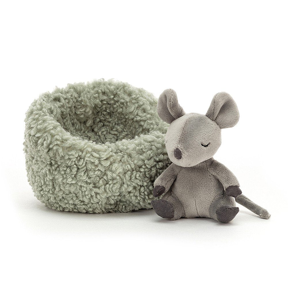 little grey jellycat mouse sitting next to his grey cushion bed