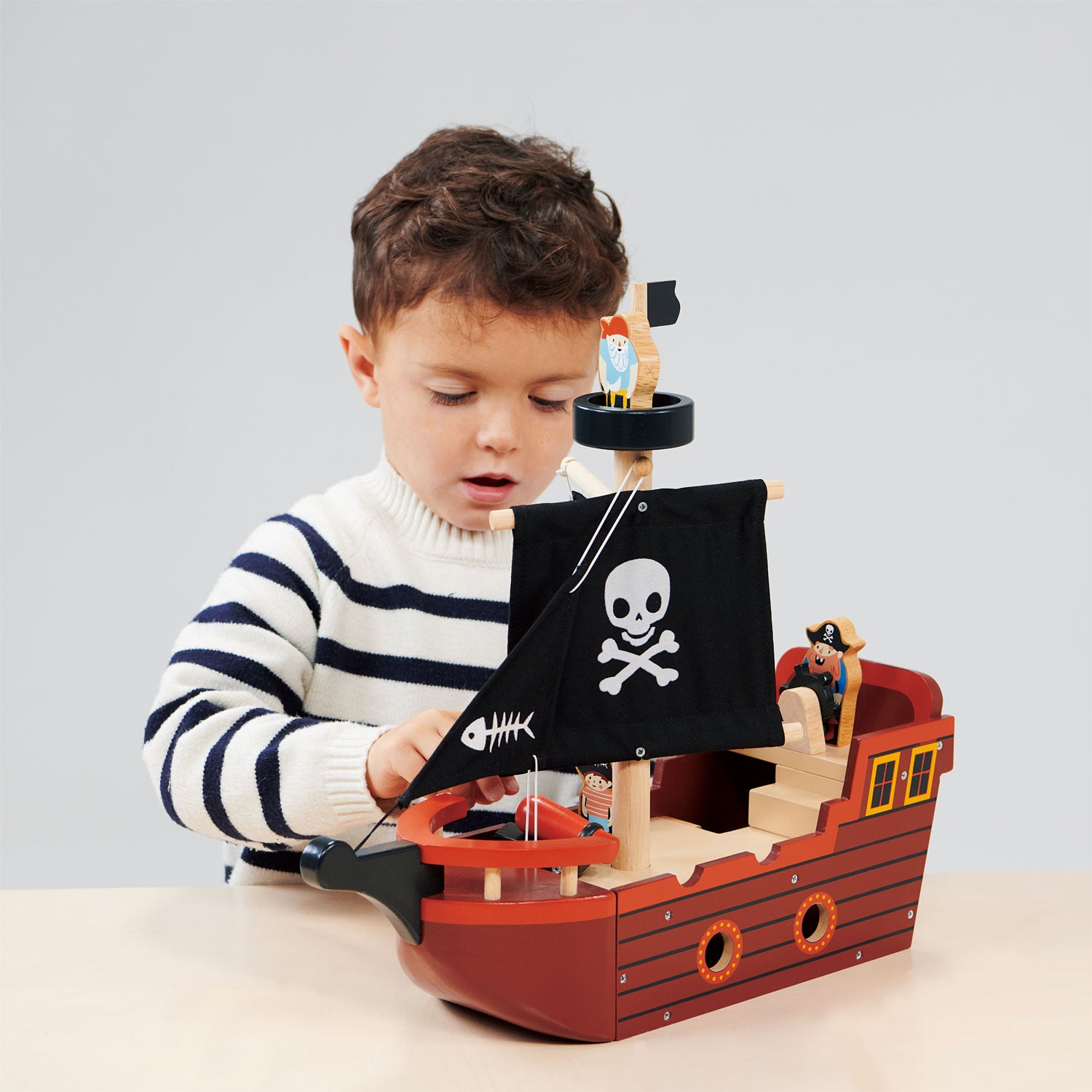 boy playing with mentari wooden pirate ship