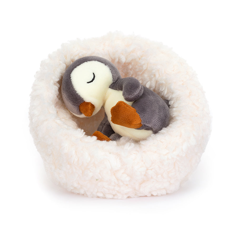 JellycatHibernating penguin is a sweet little penguin nessled in a white fur bed